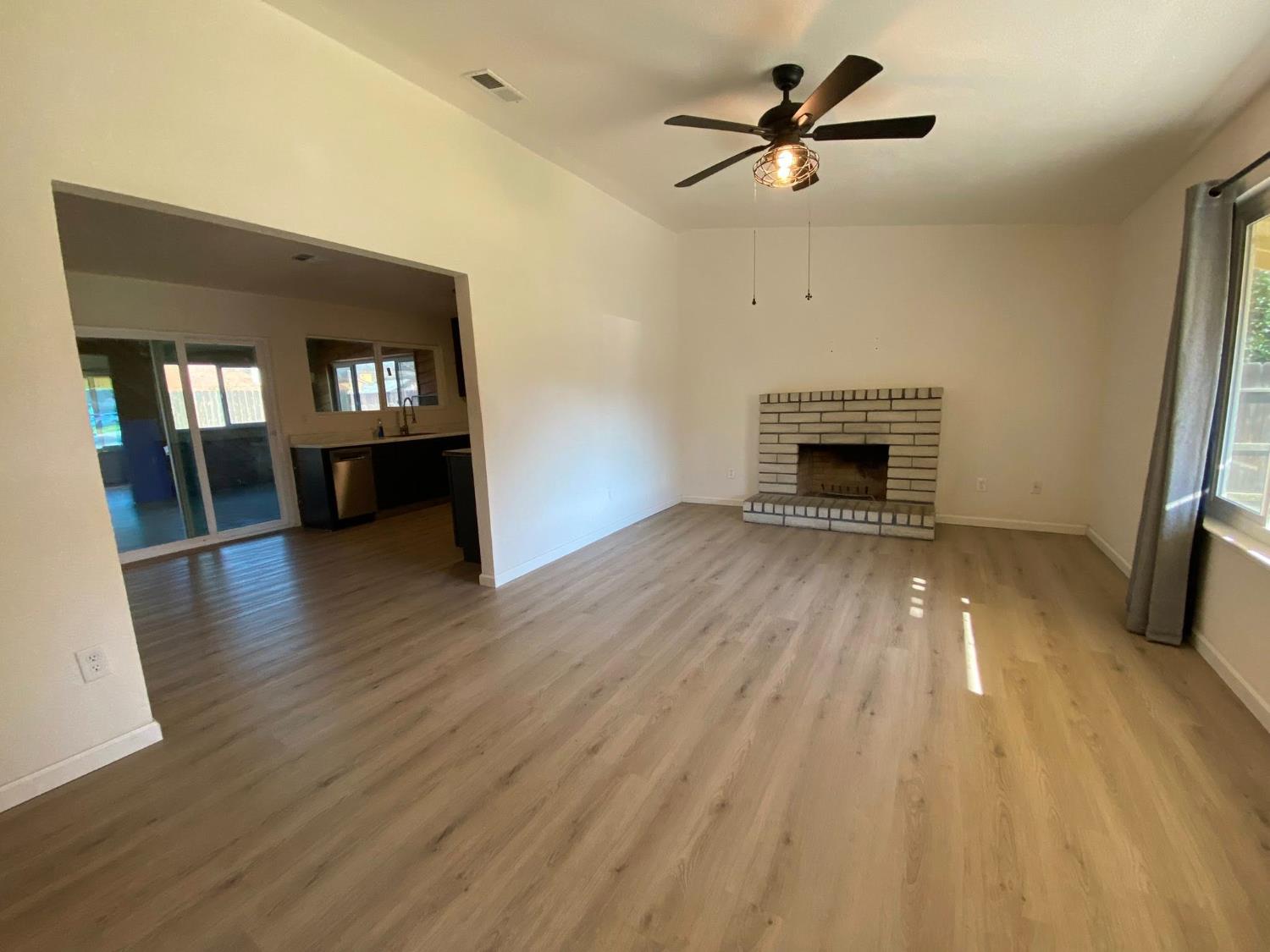 1201 Chateaugay Drive Modesto, CA 95356 - Photo 17 of 32 a view of main area fire place window and wooden floor