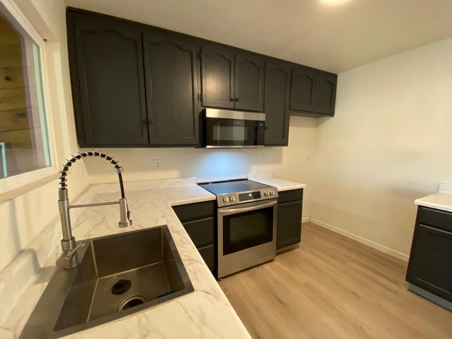 1201 Chateaugay Drive Modesto, CA 95356 - Photo 3 of 32 a kitchen with granite countertop wooden cabinets and stainless steel appliances