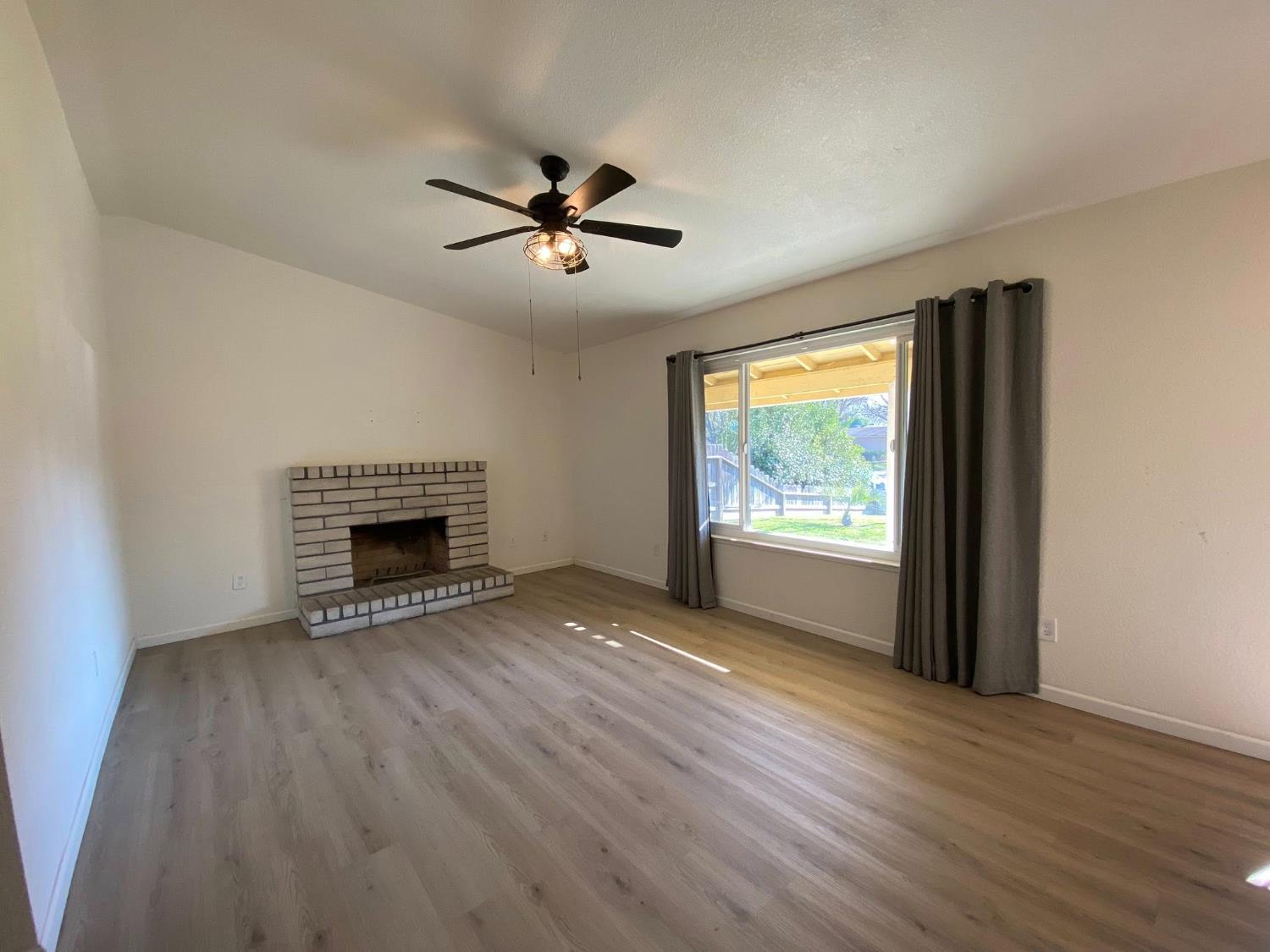 1201 Chateaugay Drive Modesto, CA 95356 - Photo 6 of 32 wooden floor in an empty room with a fireplace