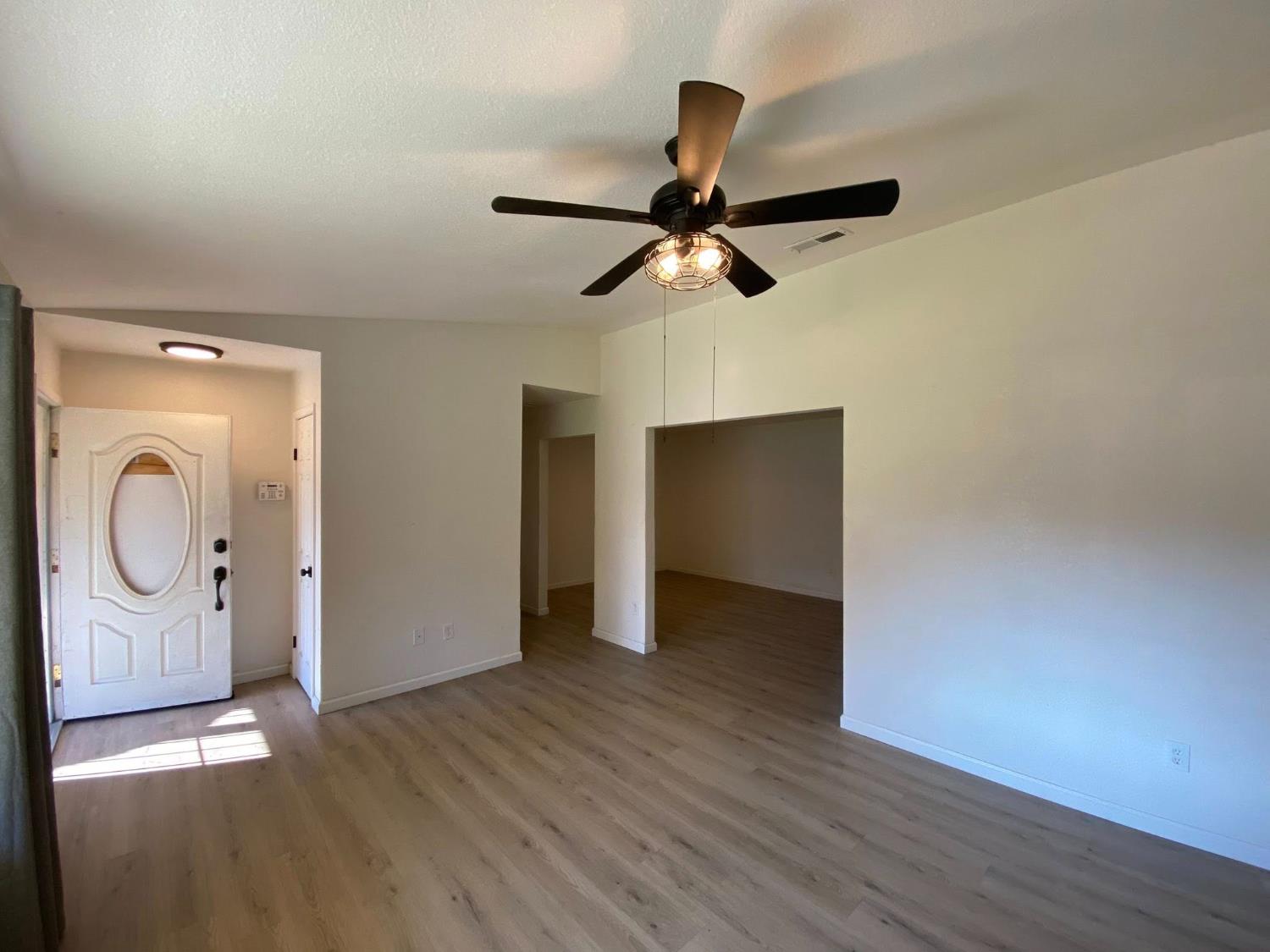 1201 Chateaugay Drive Modesto, CA 95356 - Photo 7 of 32 an empty room with wooden floor cabinet and a mirror