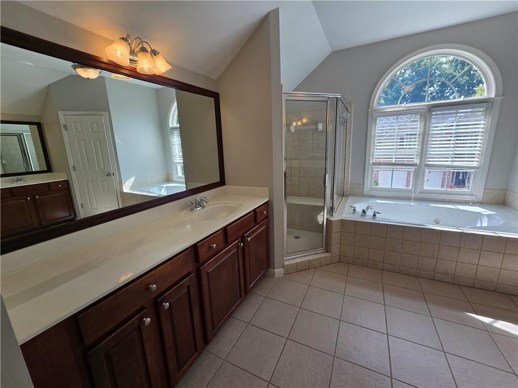 624 Maple Grove Way Marietta, GA 30066 - Photo 14 of 27 a spacious bathroom with a granite countertop sink a mirror and a bathtub