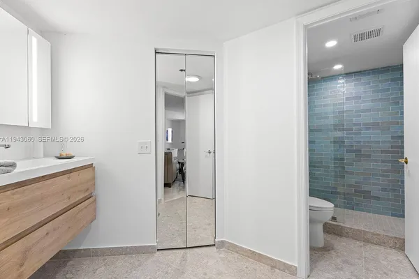 a bathroom with a granite countertop sink a toilet and shower