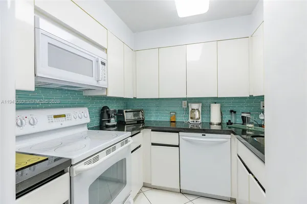 a kitchen with granite countertop cabinets stainless steel appliances and a sink
