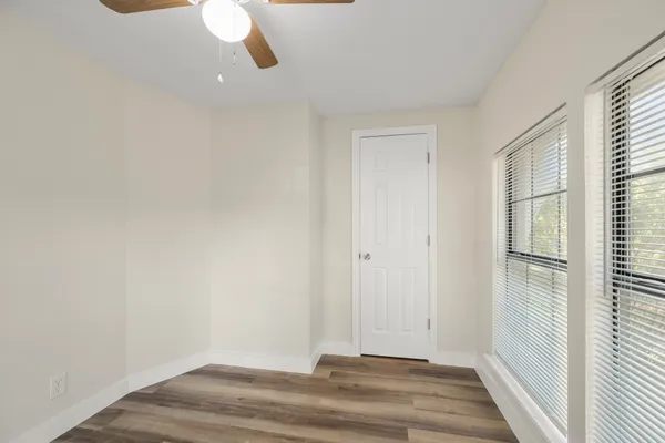 a view of a room with wooden floor and windows