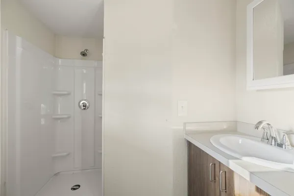 a bathroom with a granite countertop sink a shower and a mirror