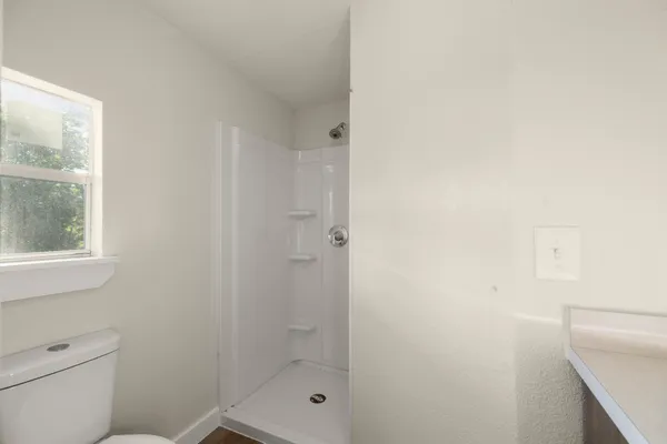 a bathroom with a shower a toilet and sink