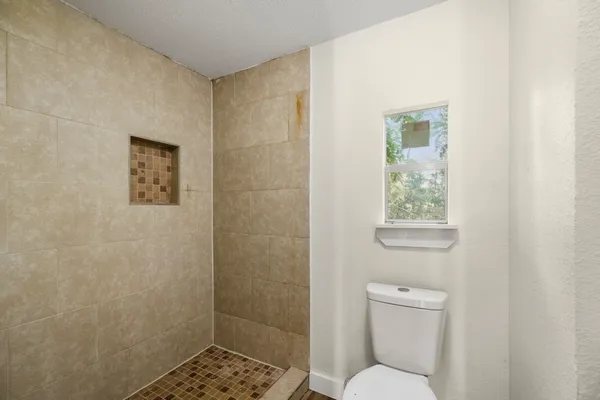 a bathroom with a toilet and a shower