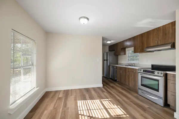 a kitchen with granite countertop a stove a sink and a refrigerator