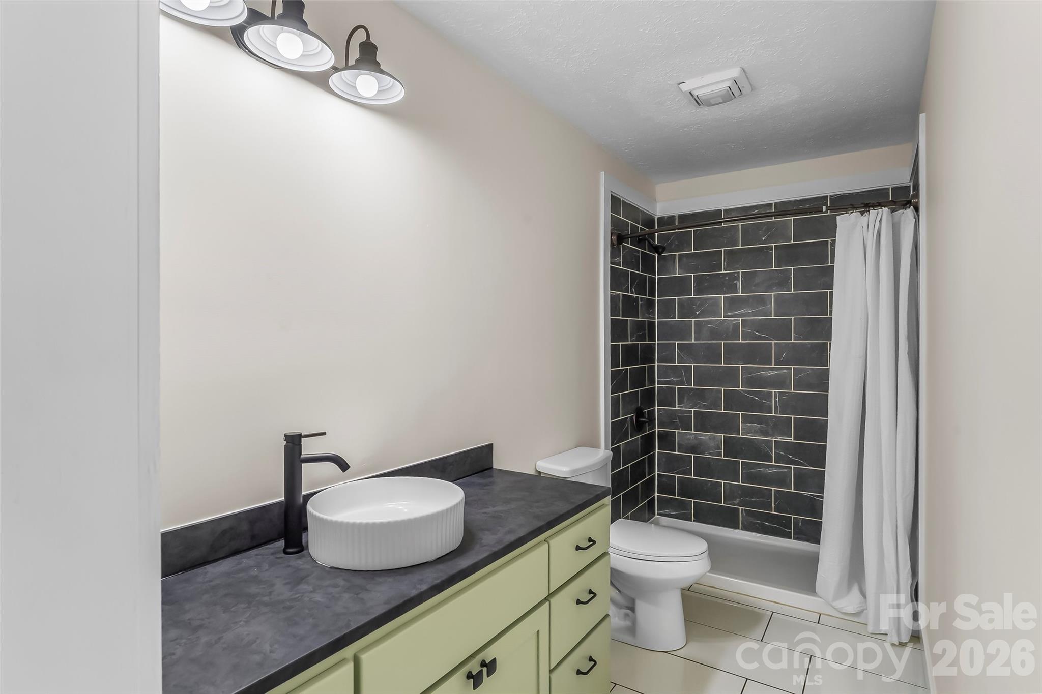 825 South Creek Road Nebo, NC 28761 - Photo 20 of 34 a bathroom with a granite countertop toilet a sink and a mirror