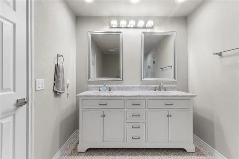 a bathroom with a double vanity sink and mirror