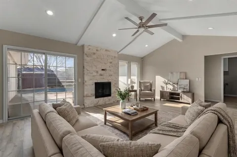 a living room with furniture a large window and a fireplace