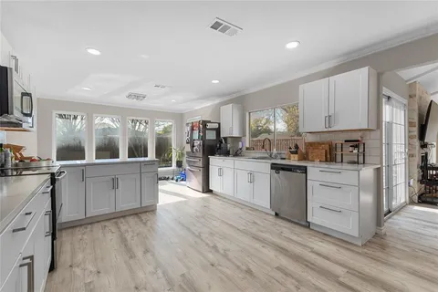 a kitchen with granite countertop white cabinets and white appliances