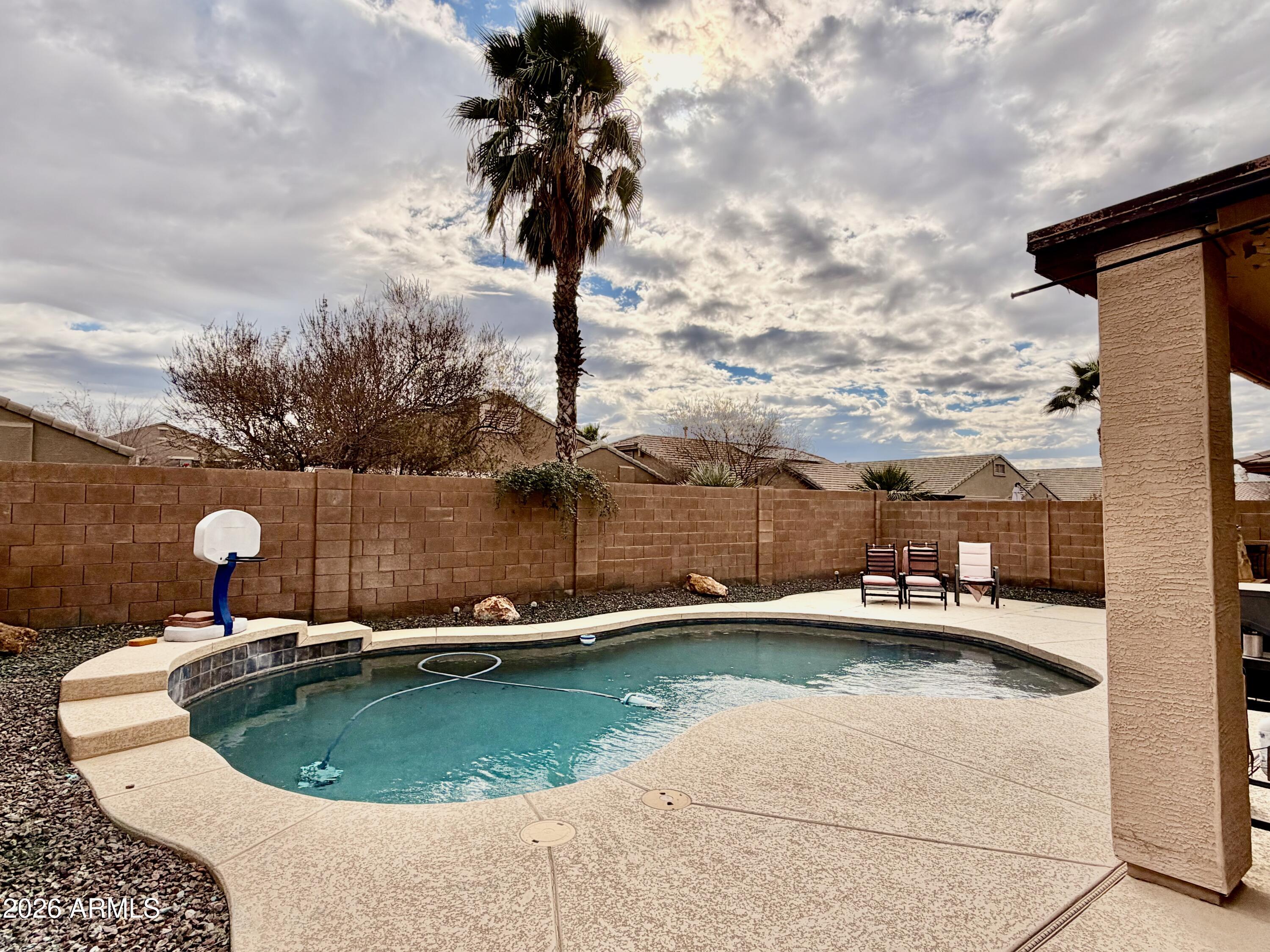 42645 West Venture Road Maricopa, AZ 85138 - Photo 12 of 37 a view of a swimming pool with a yard and wooden fence