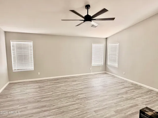 a view of a big room with wooden floor and windows