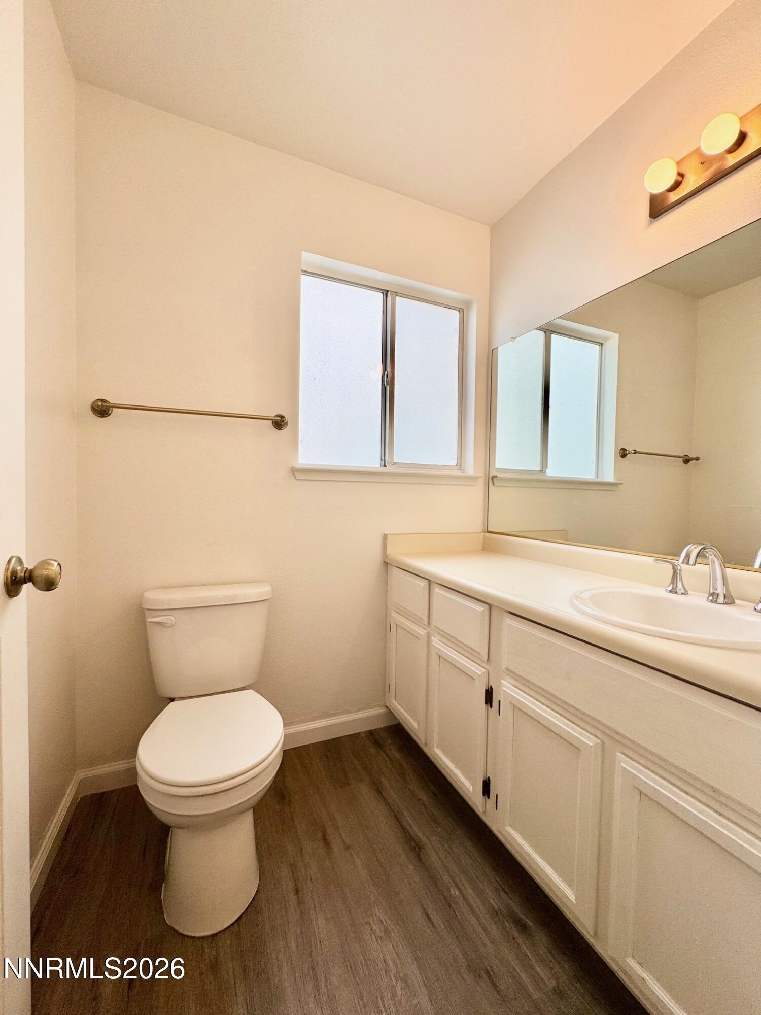 7541 Lighthouse Lane Reno, NV 89511 - Photo 10 of 24 a bathroom with a toilet a sink and mirror