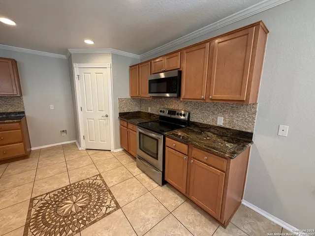 a large kitchen with granite countertop a sink and a stove top oven