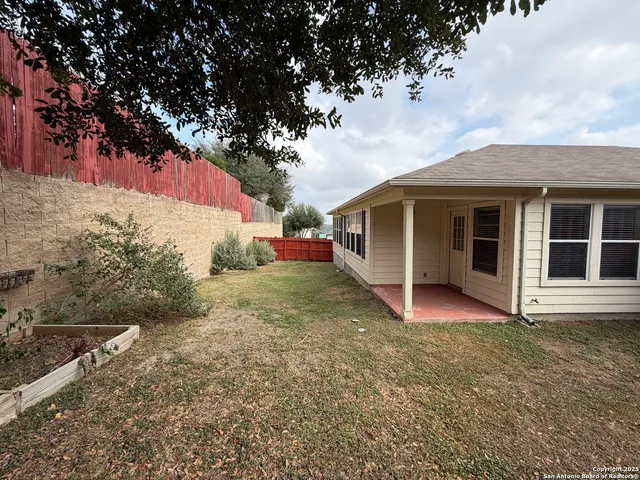 a view of a house with backyard and trees