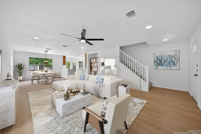 a living room with furniture and a wooden floor