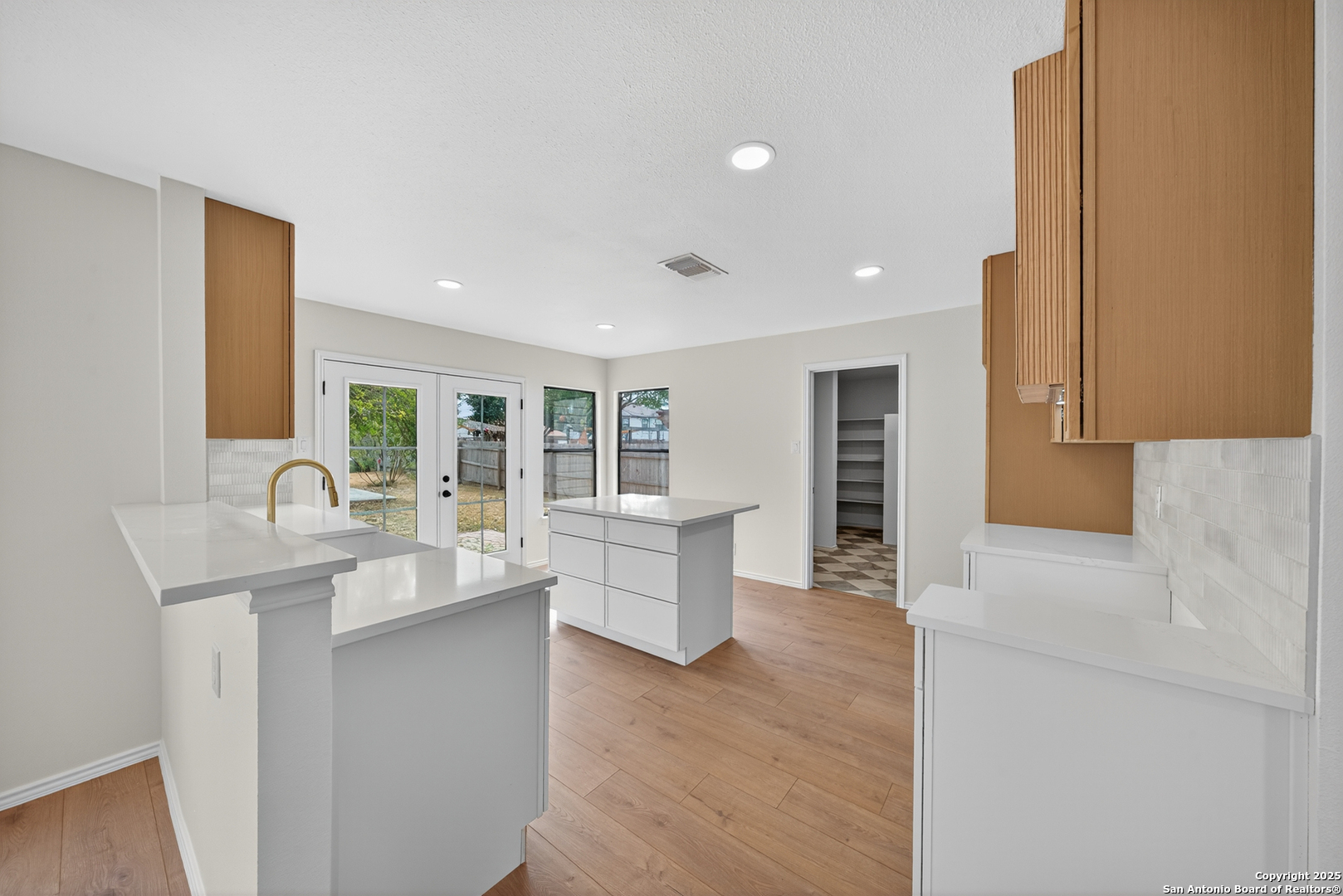 12110 Branding Point Helotes, TX 78023 - Photo 11 of 40 a large white kitchen with wooden floor and a sink
