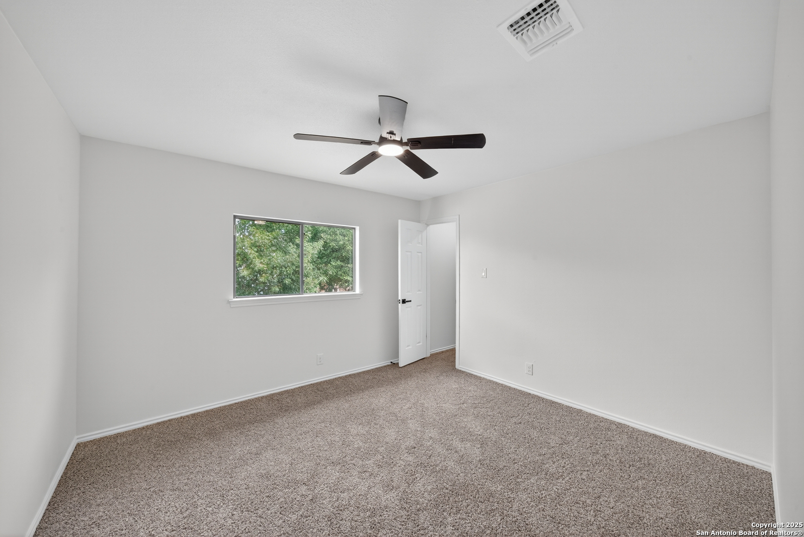 12110 Branding Point Helotes, TX 78023 - Photo 25 of 40 an empty room with a ceiling fan and a window