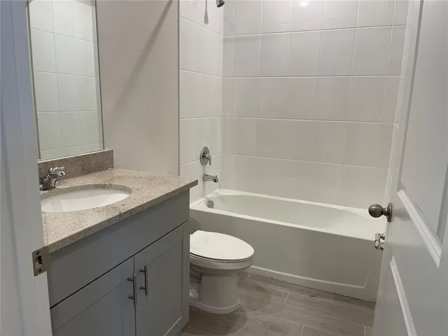 a bathroom with a granite countertop toilet a sink and bathtub