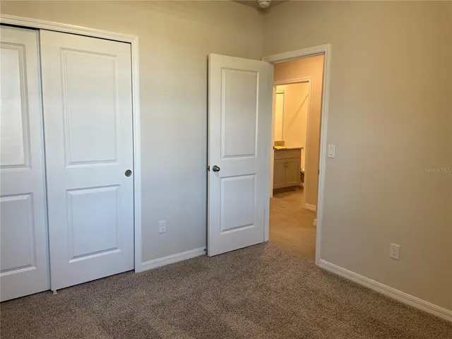 a view of an empty room with closet area