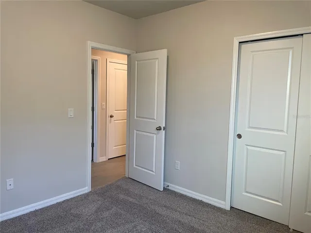 an empty room with closet and a bathroom