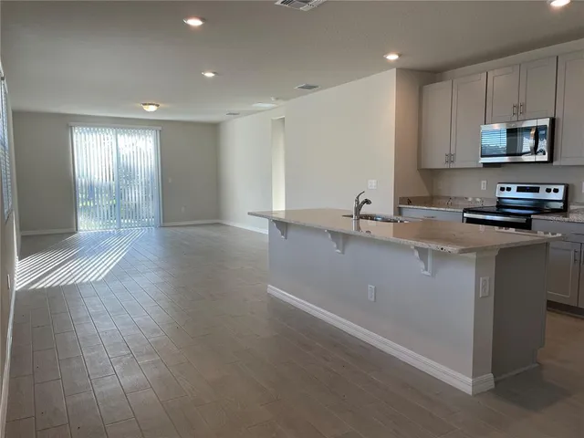 a kitchen with granite countertop a sink stainless steel appliances and cabinets