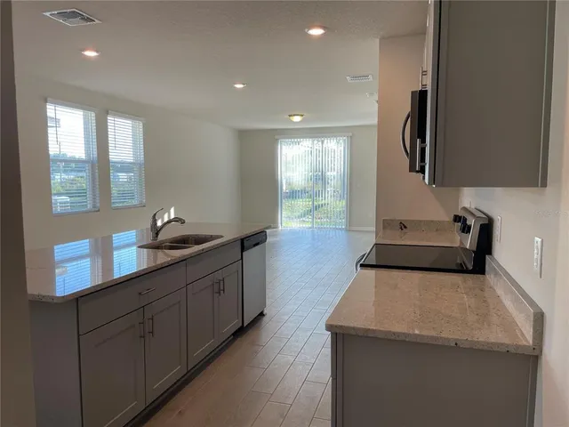 a kitchen with sink and mirror