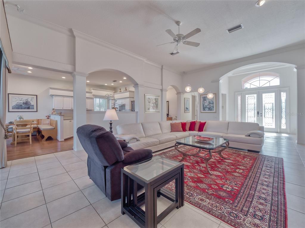 6631 Waters Edge Way Lakewood Ranch, FL 34202 - Photo 20 of 78 a living room with furniture a dining table and a chandelier