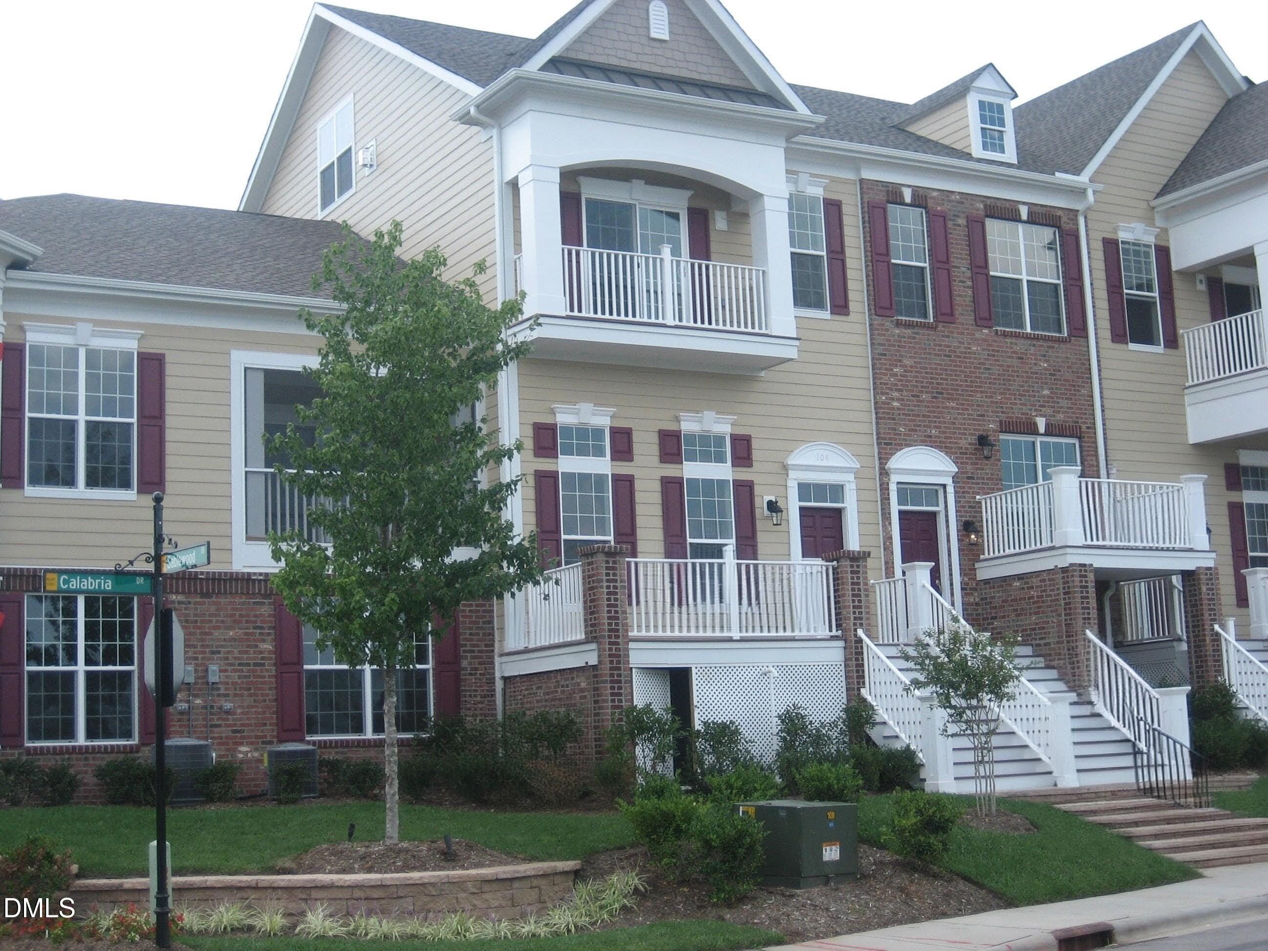 a front view of a house with a yard and plants