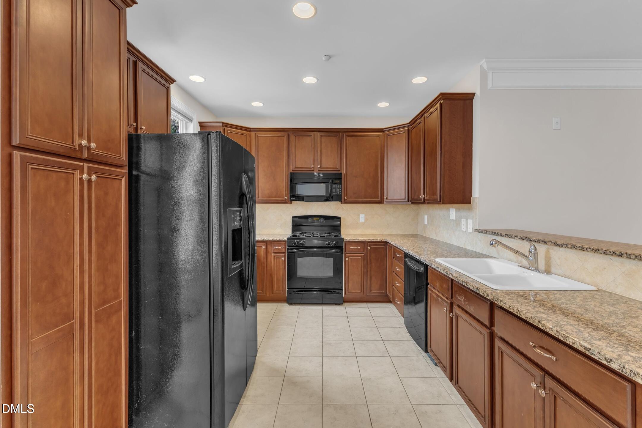9211 Calabria Drive, Unit 104 Raleigh, NC 27617 - Photo 11 of 45 a large kitchen with stainless steel appliances granite countertop a refrigerator and a sink