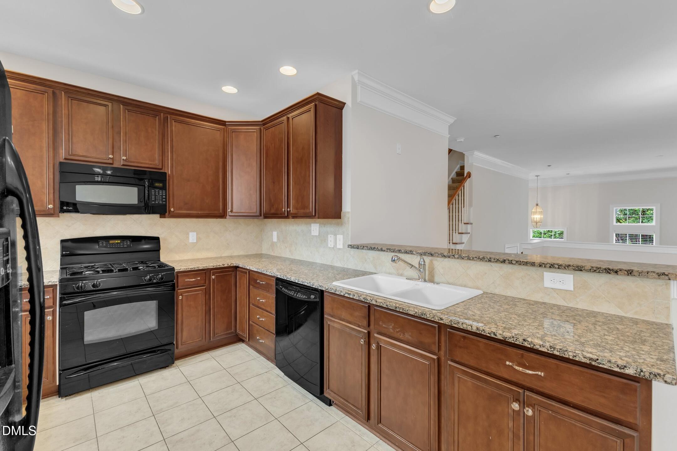 9211 Calabria Drive, Unit 104 Raleigh, NC 27617 - Photo 12 of 45 a kitchen with stainless steel appliances granite countertop a sink stove and microwave