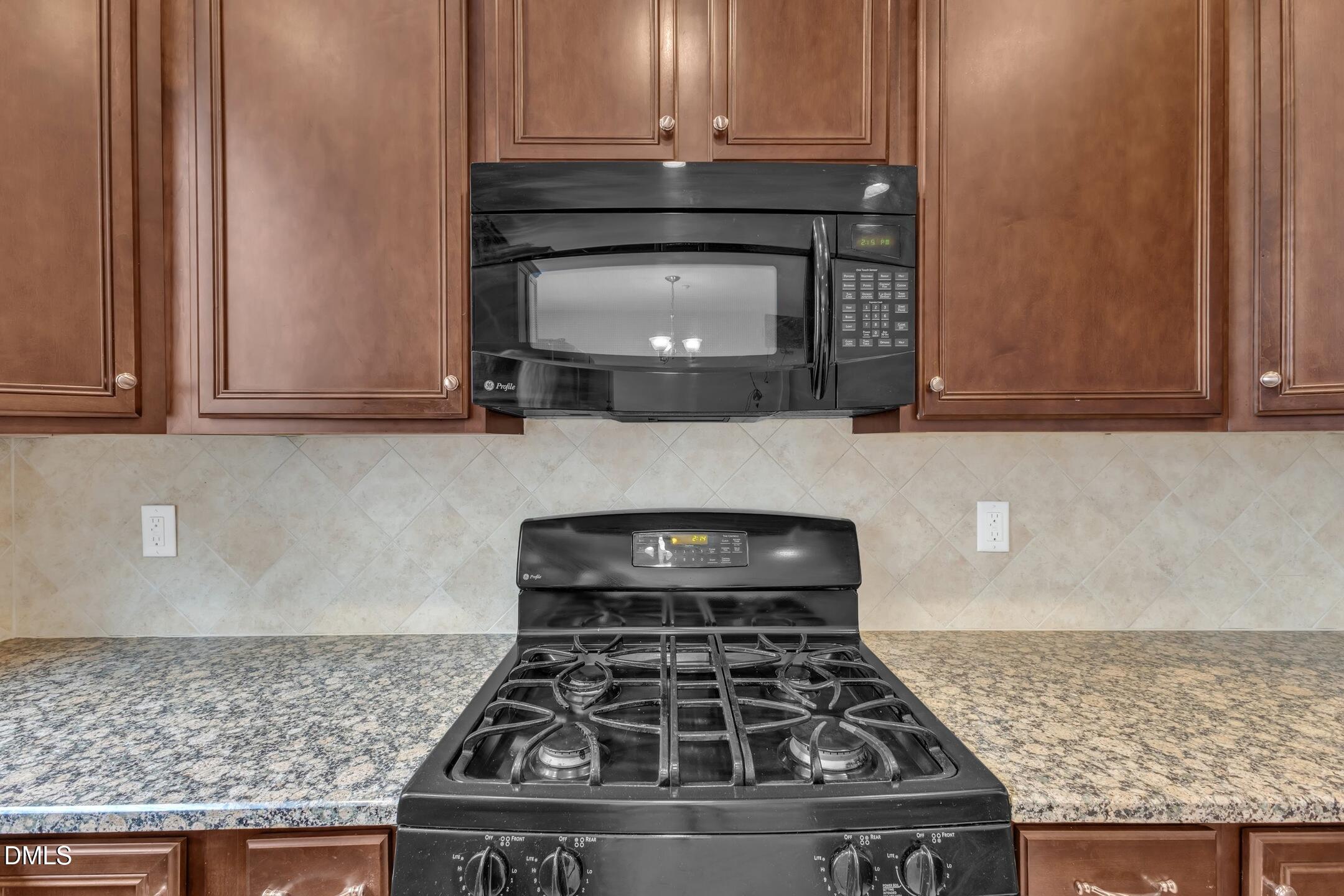9211 Calabria Drive, Unit 104 Raleigh, NC 27617 - Photo 13 of 45 a kitchen with granite countertop a stove and a microwave