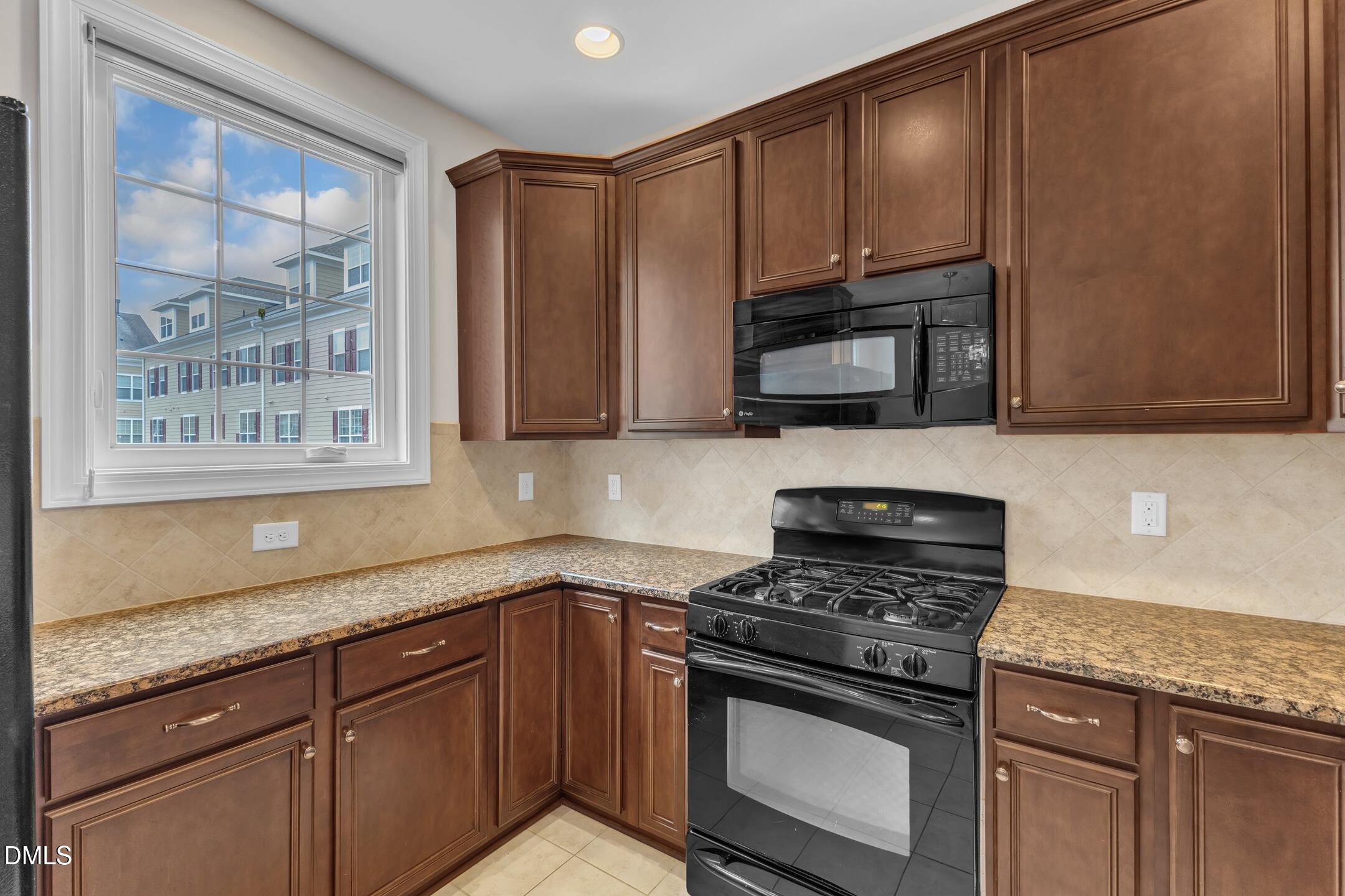 9211 Calabria Drive, Unit 104 Raleigh, NC 27617 - Photo 16 of 45 a kitchen with granite countertop cabinets stainless steel appliances and a sink