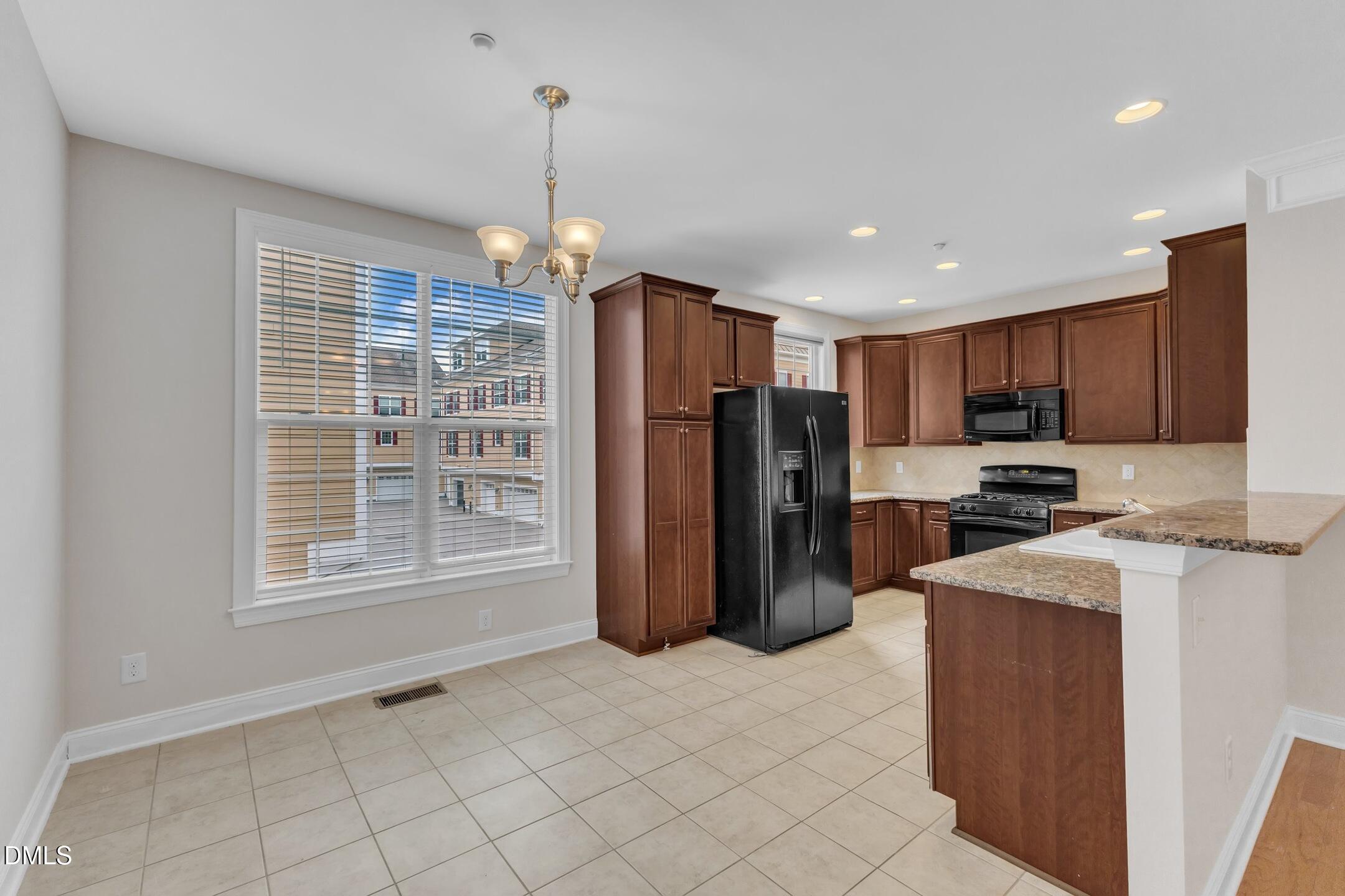 9211 Calabria Drive, Unit 104 Raleigh, NC 27617 - Photo 17 of 45 a kitchen with stainless steel appliances granite countertop a refrigerator and a sink