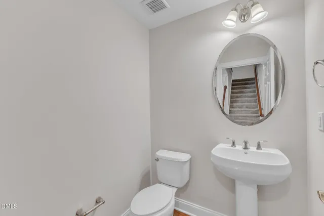 a bathroom with a toilet a sink and mirror