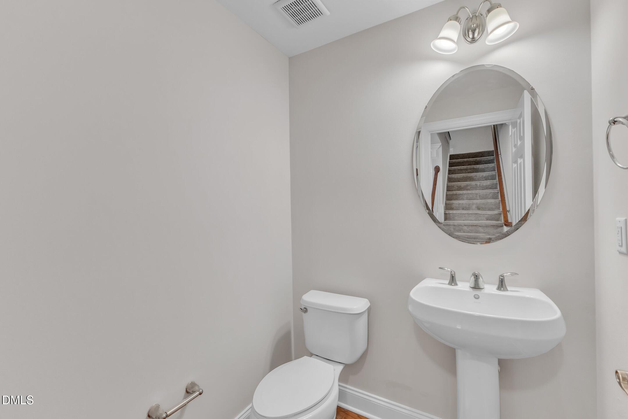 9211 Calabria Drive, Unit 104 Raleigh, NC 27617 - Photo 19 of 45 a bathroom with a toilet a sink and mirror