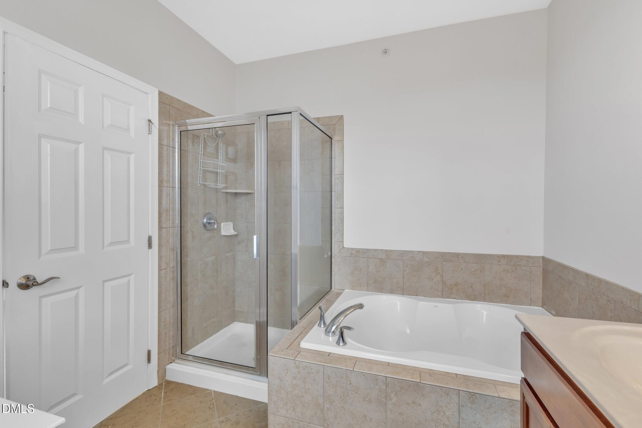 9211 Calabria Drive, Unit 104 Raleigh, NC 27617 - Photo 20 of 45 a bathroom with a tub a shower and a sink