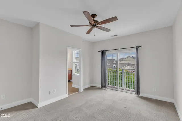 a view of a livingroom with a ceiling fan & windows