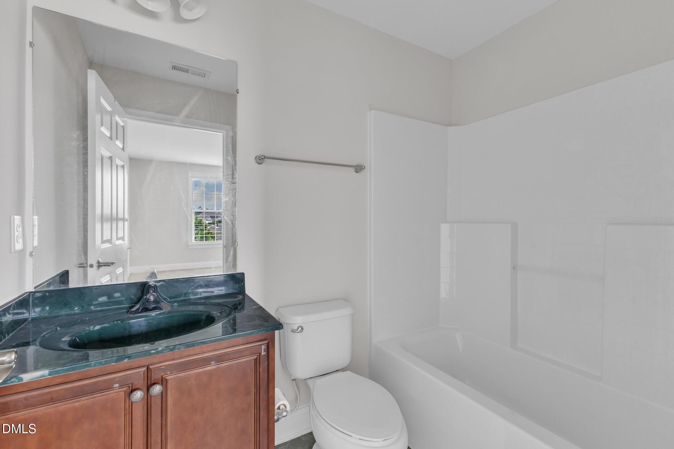 9211 Calabria Drive, Unit 104 Raleigh, NC 27617 - Photo 32 of 45 a bathroom with a granite countertop sink a toilet and shower