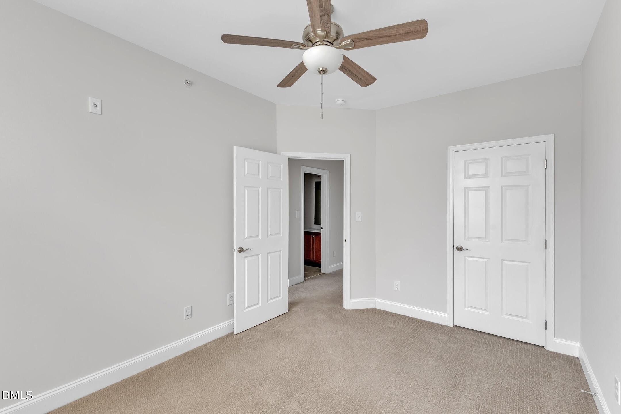 9211 Calabria Drive, Unit 104 Raleigh, NC 27617 - Photo 34 of 45 an empty room with closet and a ceiling fan