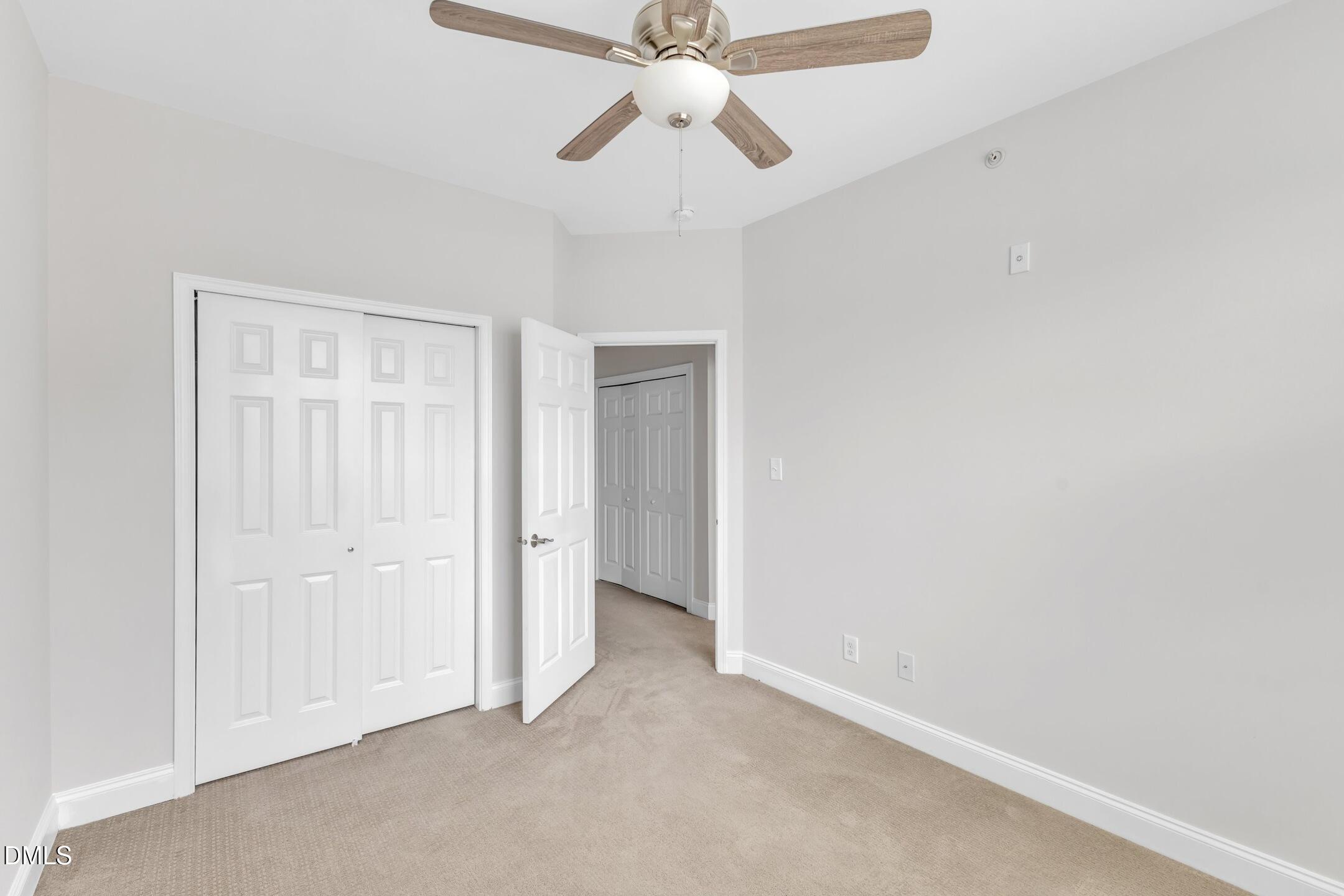 9211 Calabria Drive, Unit 104 Raleigh, NC 27617 - Photo 36 of 45 an empty room with a chandelier fan and closet