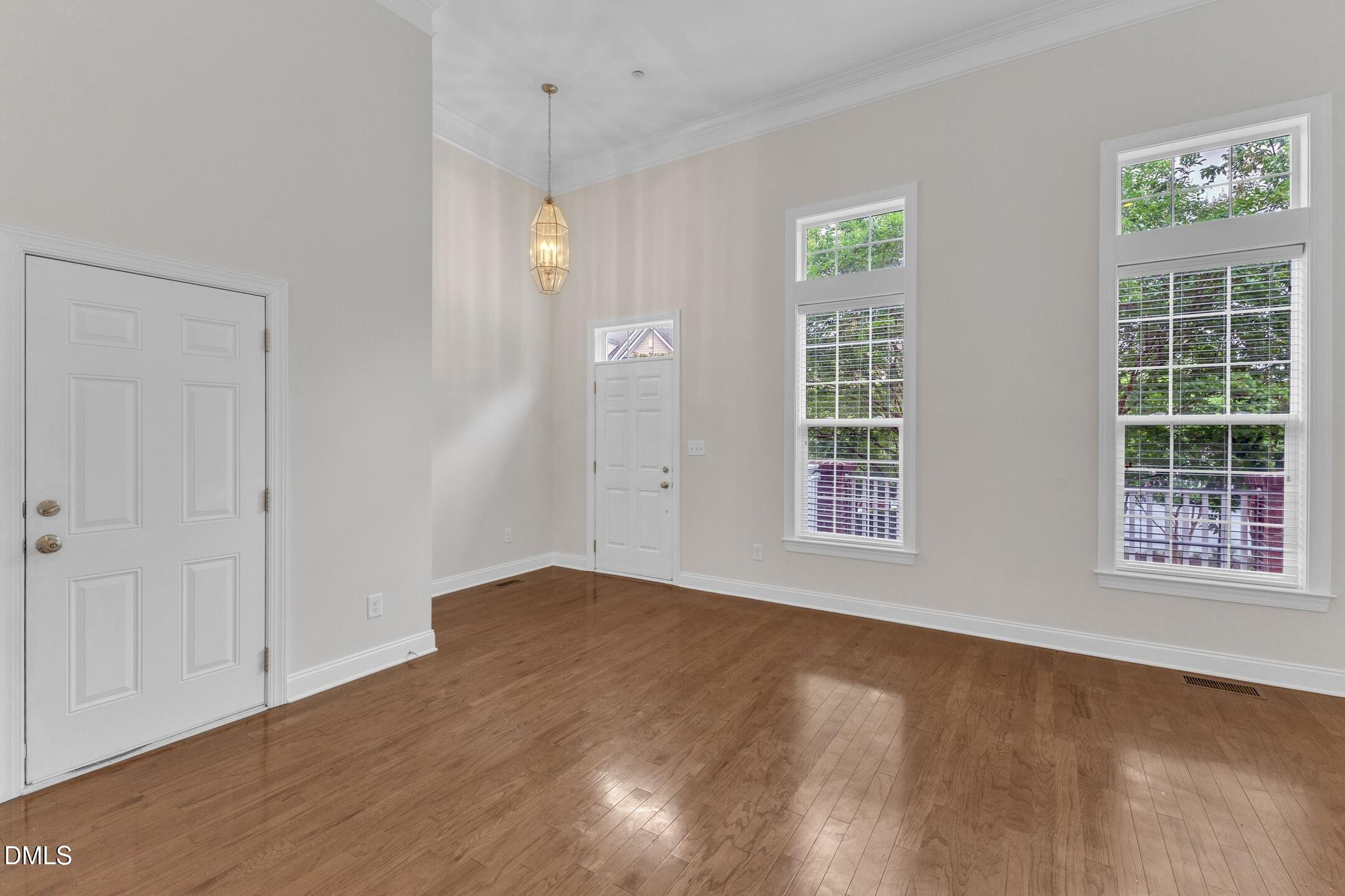 9211 Calabria Drive, Unit 104 Raleigh, NC 27617 - Photo 4 of 45 a view of an empty room with a window and wooden floor