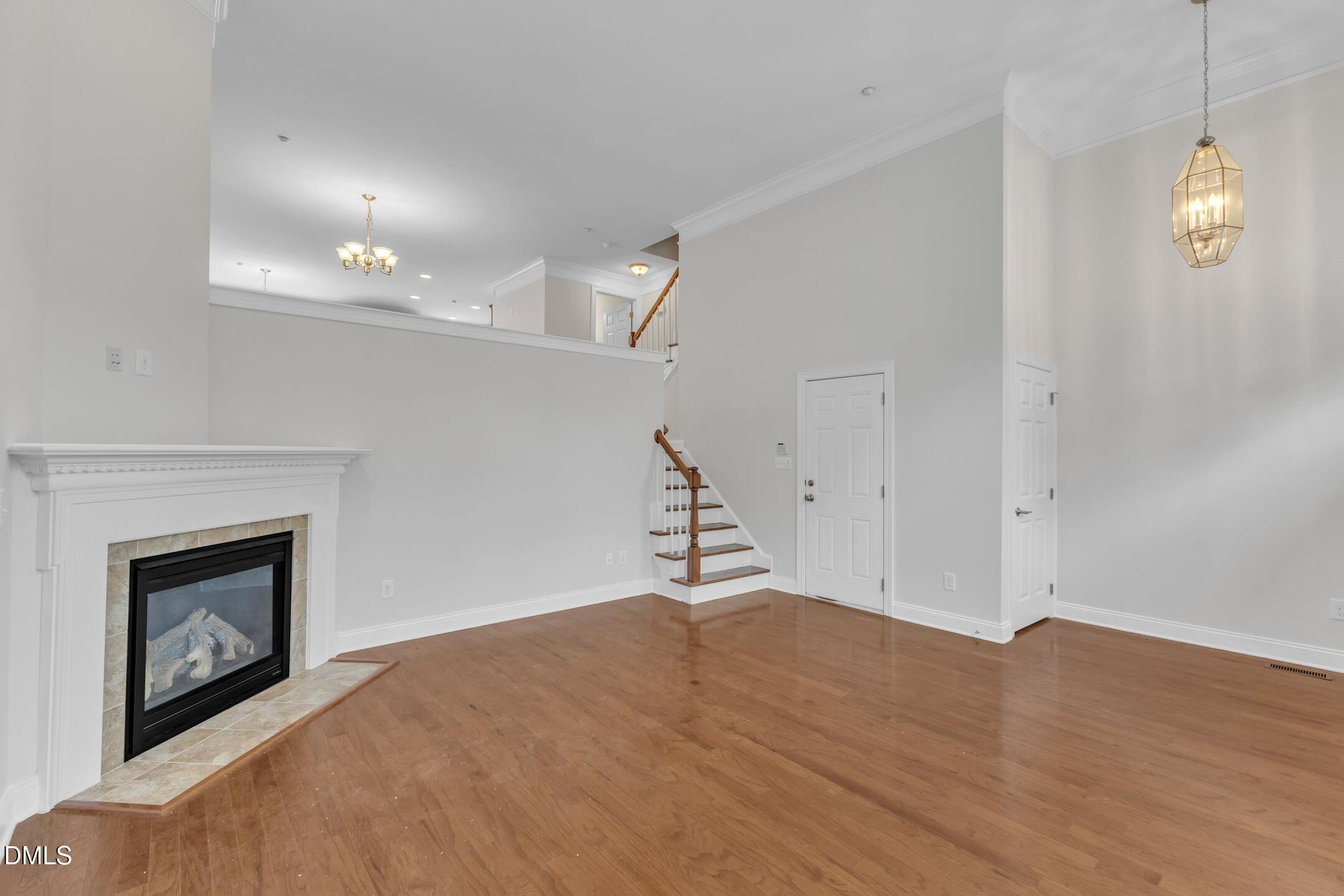 9211 Calabria Drive, Unit 104 Raleigh, NC 27617 - Photo 7 of 45 a view of an empty room with wooden floor and a fireplace