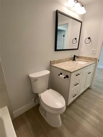 a spacious bathroom with a toilet a sink and mirror