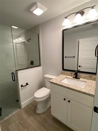 a bathroom with a granite countertop sink toilet and shower