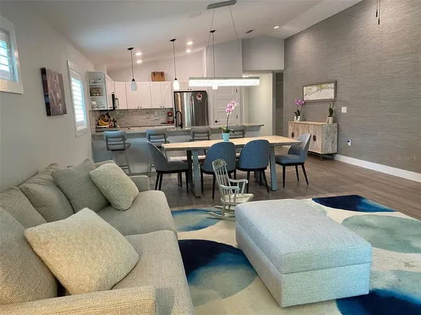 a living room with furniture kitchen view and a table