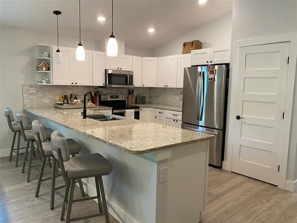 a kitchen with kitchen island a counter space a sink appliances and cabinets