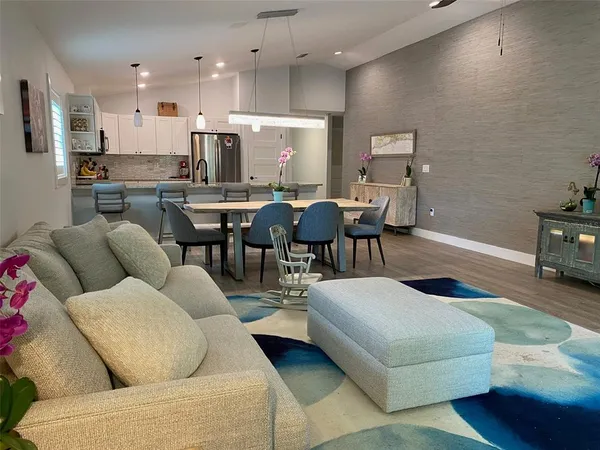 a living room with furniture kitchen view and a dining table